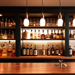 **

A cozy home bar illuminated with warm (2700-3000K) pendant lights hanging above a wooden bar top. Display a variety of liquor bottles and glassware on shelves with subtle, warm-toned indirect lighting. The overall aesthetic should be inviting and relaxed, perfect for winding down after work.

**